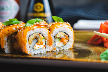 Traditional Japanese rolls with salmon fish, eel, seafood on a plate with wooden chopsticks