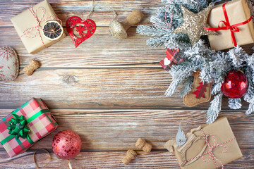 Christmas decorations, gifts and christmas balls are on on wooden background. Background on the New Year theme in the form of a frame. Free space for text in the center. View from the top point.