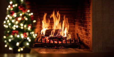 Christmas tree and burning fireplace, bonfire and festive decoration, bokrh lights.