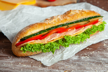 Breakfast of Fresh croissant with ham, cheese and salad leaf on white wooden background.