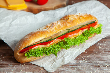 Breakfast of Fresh croissant with ham, cheese and salad leaf on white wooden background.