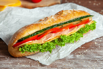 Breakfast of Fresh croissant with ham, cheese and salad leaf on white wooden background.