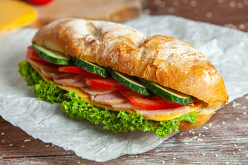 Breakfast of Fresh croissant with ham, cheese and salad leaf on white wooden background.