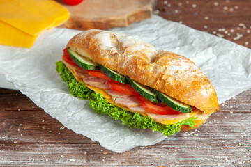 Breakfast of Fresh croissant with ham, cheese and salad leaf on white wooden background.