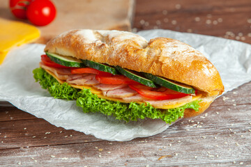 Breakfast of Fresh croissant with ham, cheese and salad leaf on white wooden background.