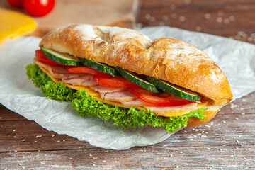 Breakfast of Fresh croissant with ham, cheese and salad leaf on white wooden background.