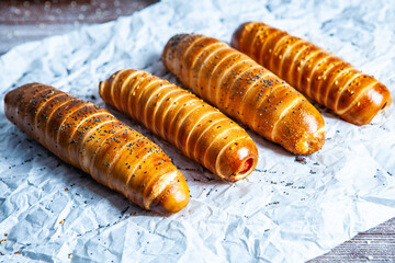 Fresh tasty sausage rolls on plate. fresh sausage in dough on wood background.