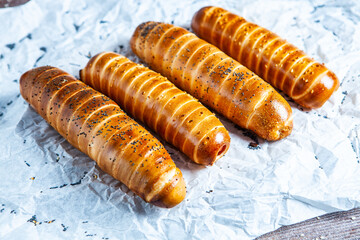 Fresh tasty sausage rolls on plate. fresh sausage in dough on wood background.