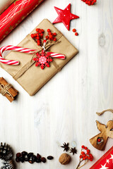 Christmas background (postcard) with place for text in the center. Wrapping paper, gift, pine cones and other decorative elements on a white wooden background