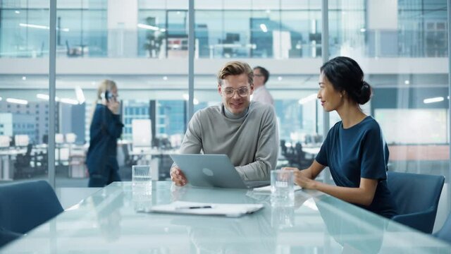 Multiethnic Diverse Office Conference Room Meeting: Team of Two Creative Entrepreneurs Talk, Discuss Growth Strategy. Stylish Young Businesspeople work on Investment and Marketing Projects.