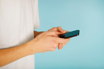 Close up of a man using mobile smart phone over blue background