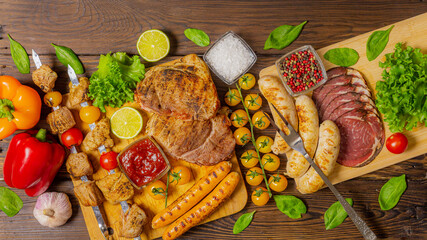 Grilled meat, sausages, kebab, steak and vegetables on rustic wooden table. Meat feast on table. Grill set on picnic plate. Top view
