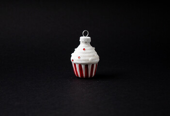 Christmas tree decoration cupcake with snow on top. Front view with dark black background.