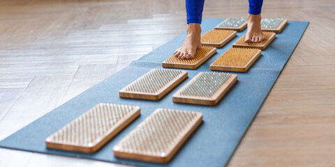 Female feet walking on a board with sharp nails over white background. Sadhu's board - practice...