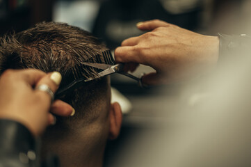 Young bearded man getting haircut by hairdresser