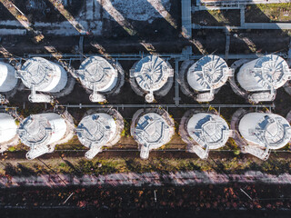 Aerial top down view of vertical white fuel storage tanks.