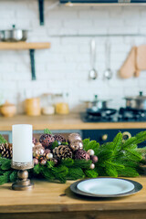 Empty plates on wooden table close-up. Decorated Christmas tree in kitchen. Table setting on New Years in interior...