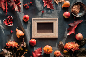 Blackboard, frame and Autumn decor. Chrysanthemum flowers, bunny tail grass and red oak leaves, pumpkins, cranberry. Autumn decorations, top view. Flat lay on dark textile with copy-space, text place.