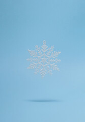 creative Christmas snowflake with sunny shadow against pastel blue background. minimal modern...