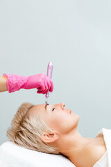 Anti-aging treatment and face lift. Adult woman at a mesotherapy session in a professional clinic...