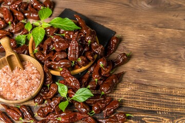 Chili pepper on wooden background.Extra hot chili. Naga Bhut Jolokia Chocolate. Exotic spices. Hot ingredients for food.
