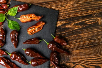 Chili pepper on wooden background.Extra hot chili. Naga Bhut Jolokia Chocolate. Exotic spices. Hot...