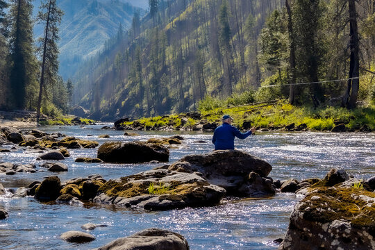 Man wading and fly fishing in the Selway River in the Idaho Selway Bitterroot wilderness.