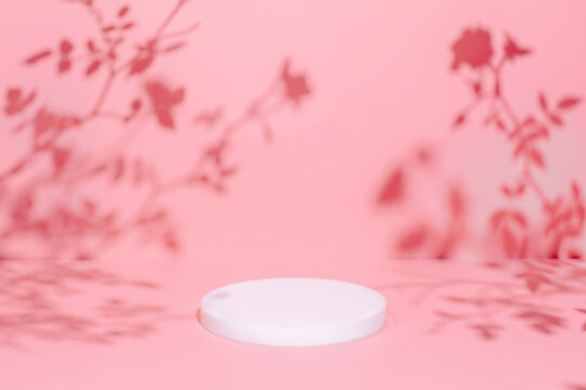 Abstract minimal nature scene - empty stage and circle podium on pink background and soft shadows of rose flowers and leaves. Pedestal for cosmetic product and packaging mockups display presentation