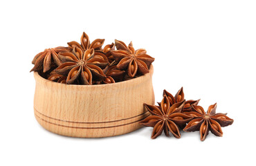 Wooden bowl and dry anise stars on white background