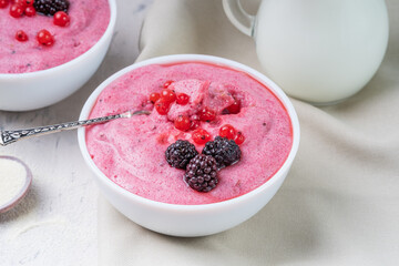 Delicious healthy dessert made from semolina and berries in a white bowl. Spoon in dessert