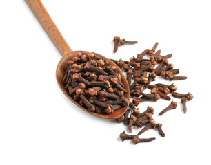 Aromatic dry cloves and wooden spoon on white background