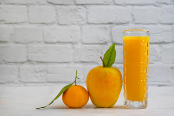 juice in a glass of orange apple on a light background