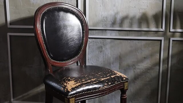 antique handmade armchair with carved wood and leather seat.