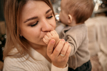 close-up of blonde mom kissing baby boy's hand