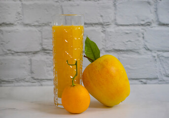 juice in a glass of orange apple on a light background