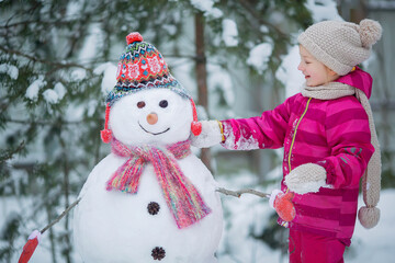 Cute girl is making a snowman.