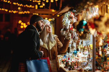 Winter holidays, vacation, travel, purchase conception. Happy smiling couple shopping at Christmas...