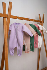 Stylish sale of costumes for children. Pajamas for a child on a hanger collection of different colors. Children's clothing store in the store.