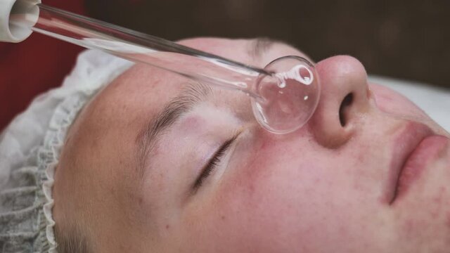 Darsonvalization of the face in a young girl with problem skin.