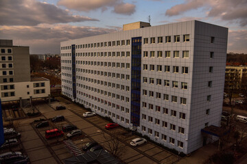 Square minimalistic hotel building in blue at the afternoon with some cars parked in Berlin, Germany
