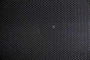 Macro shot of speaker grille. Vintage effect. Close up shot of a round speaker. Acoustic broadband speaker. Luxury car stereo system speaker. Holes in a metal lattice.