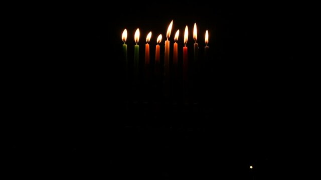 Video depicts Jewish Holiday Hanukkah with wax candles burning on menorah at night 