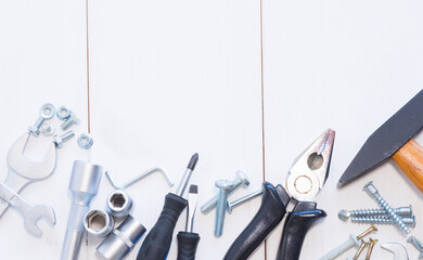 Many assorted tools on white wooden background