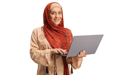 Young woman wearing a hijab and holding a laptop computer