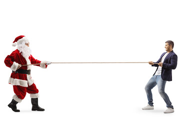 Full length profile shot of a young man and santa claus pulling a rope