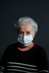 grandmother wearing a coronavirus mask on a gray background