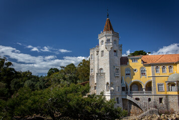 Fototapeta na wymiar Exterior of the Saint Sebastian Tower (Torre de S.Sebastiao) museum surrounded by trees under the beautiful blue sky in Cascais, Lisbon. 