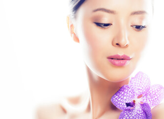 young pretty asian woman with flower purple orchid close up isolated spa smiling casual
