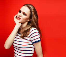 Fototapeta premium young pretty emitonal posing teenage girl on bright red background, happy smiling lifestyle people concept
