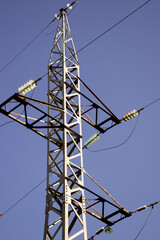 electrical network circuit steel tower with wires against clear blue sky background